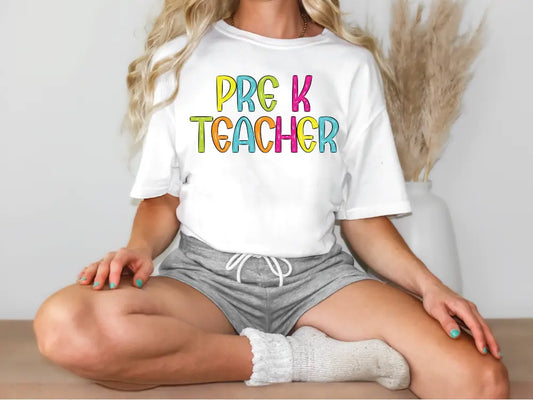 a woman sitting on a table wearing a t - shirt that says prg k