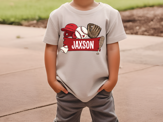 a young boy standing on a sidewalk wearing a t - shirt with a baseball glove