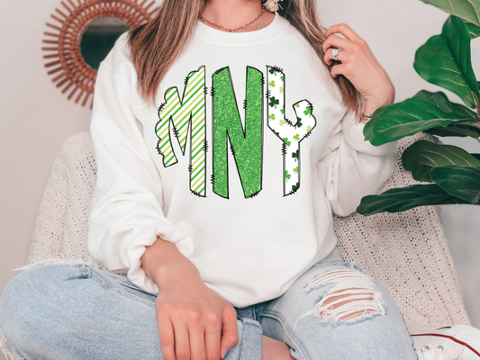 a woman sitting on a couch wearing a white sweatshirt with the letter n on it