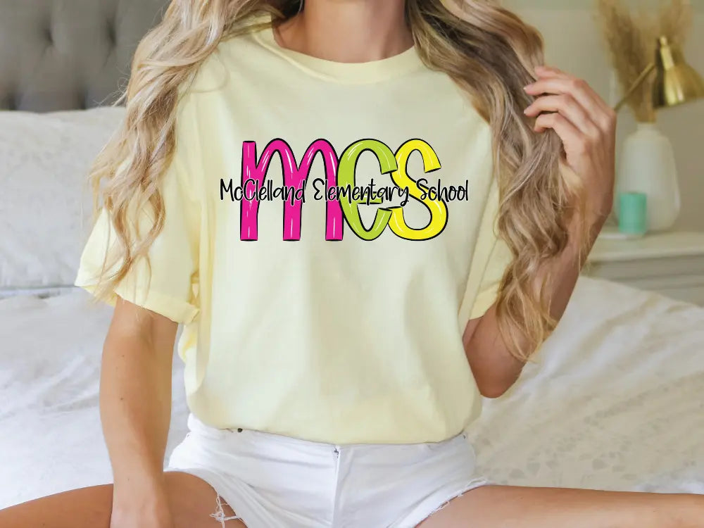 a woman sitting on a bed wearing a t - shirt that says mcs