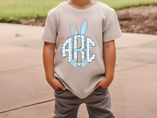 a young boy wearing a gray t - shirt with the letters abc on it