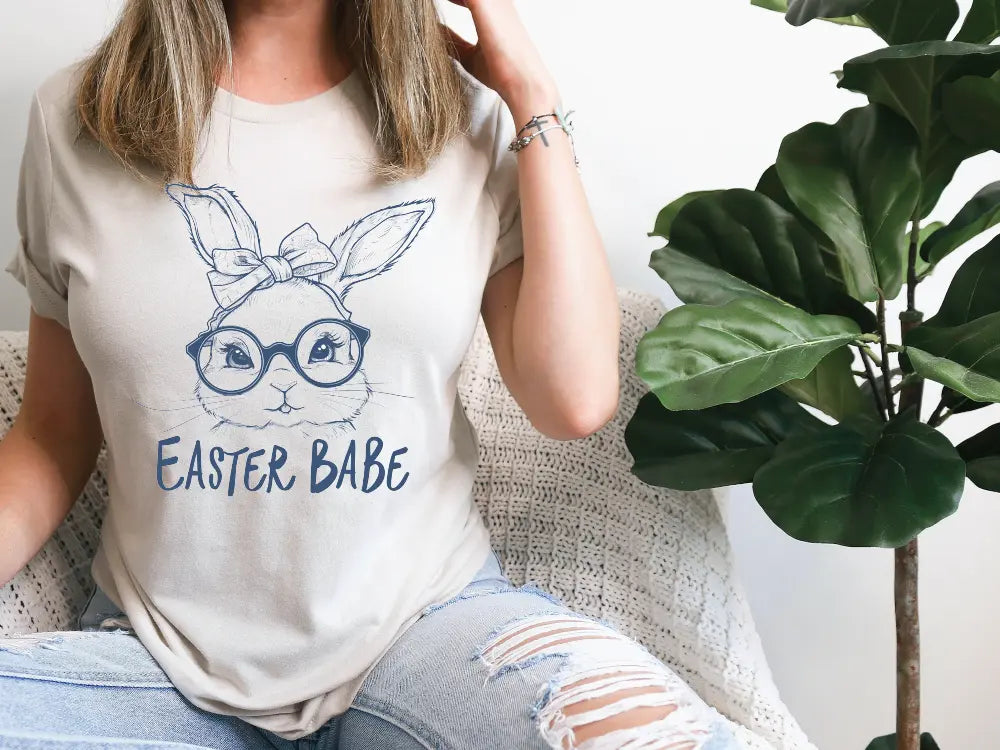 a woman sitting on a couch wearing a t - shirt that says easter babe