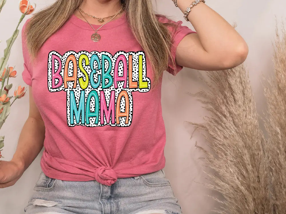 a woman wearing a pink tshirt with the words baseball mom on it